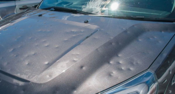 Car bonnet covered in dents caused by hail stones 