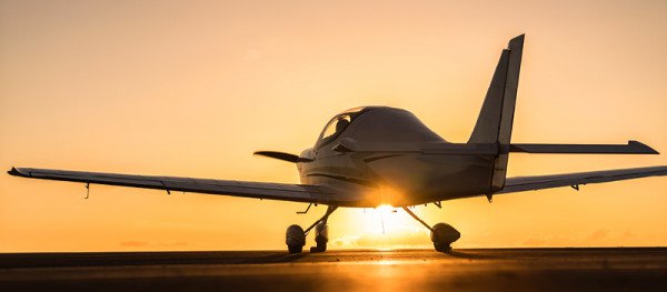 A small plane on the runway at sunset