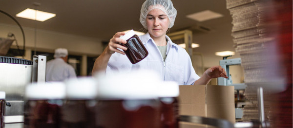 Arataki Honey staff checks a jar of honey on the production line